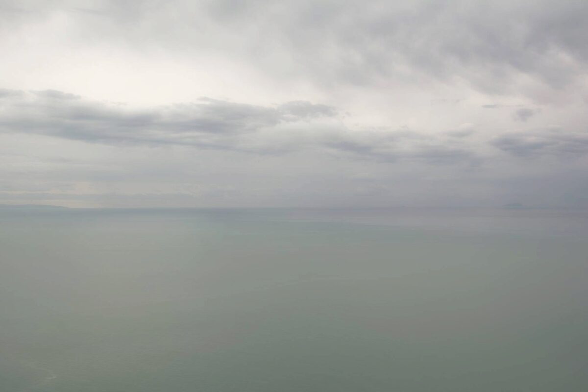 Il confine tra mare e cielo è sottile ed appena percettibile. La foschia autunnale pone un grigio velo sui colori sfavillanti di poche settimane prima.