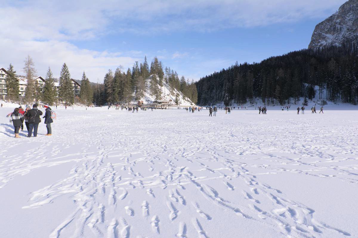 migliaia di passi impressi sulla neve che copre la superficie ghiacciata del lago di Braies
